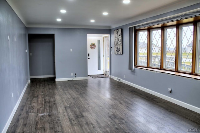 unfurnished living room featuring dark wood-style floors, visible vents, recessed lighting, and baseboards