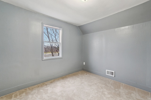 additional living space featuring lofted ceiling and light carpet