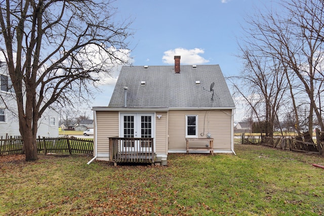 rear view of house featuring a wooden deck, a yard, and french doors