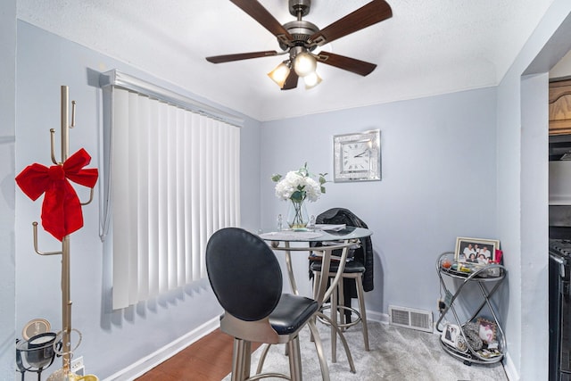 dining space with a ceiling fan, baseboards, visible vents, and a textured ceiling