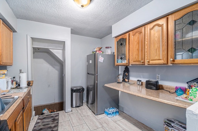 kitchen with white microwave, glass insert cabinets, light countertops, and freestanding refrigerator