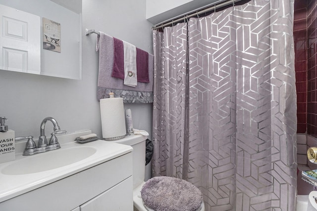 bathroom featuring toilet, vanity, and curtained shower