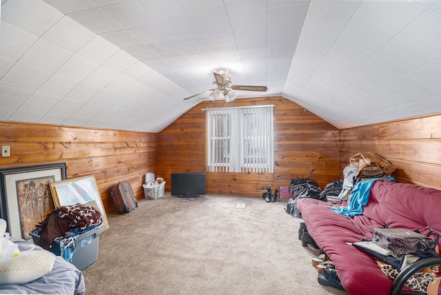 interior space featuring vaulted ceiling, wooden walls, and carpet