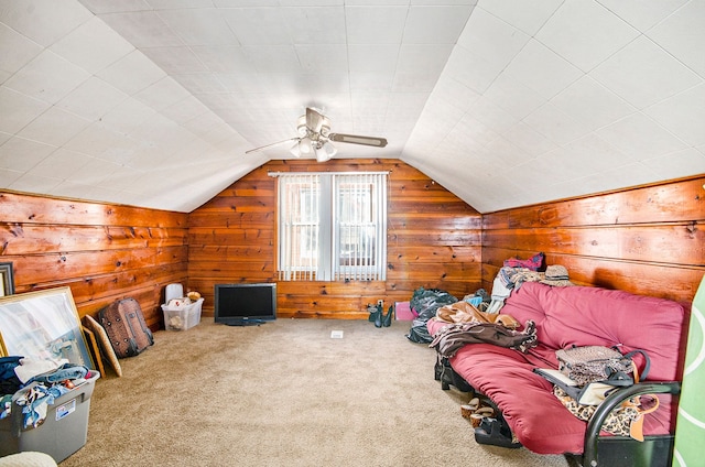 interior space featuring lofted ceiling, wooden walls, and carpet floors