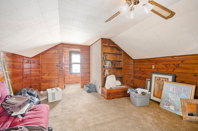 bonus room with lofted ceiling, wood walls, and carpet flooring