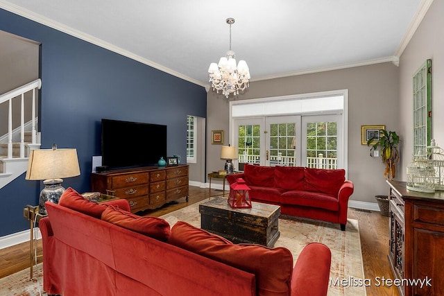 living room featuring an inviting chandelier, light hardwood / wood-style floors, and ornamental molding