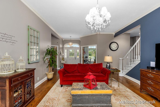 living room with wood-type flooring, ornamental molding, and an inviting chandelier