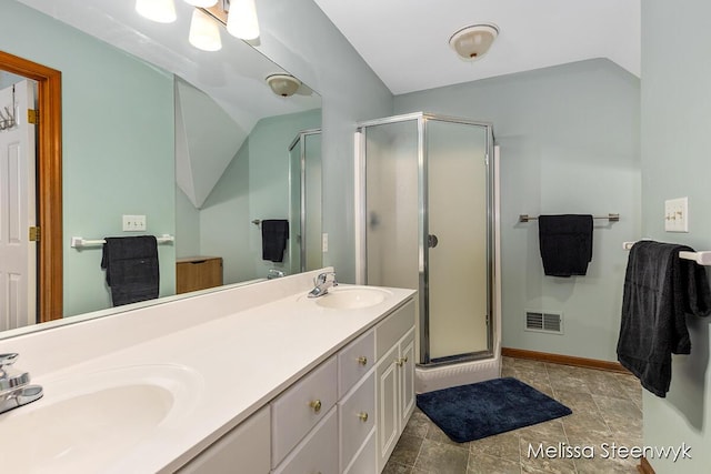 bathroom with vanity, vaulted ceiling, and an enclosed shower