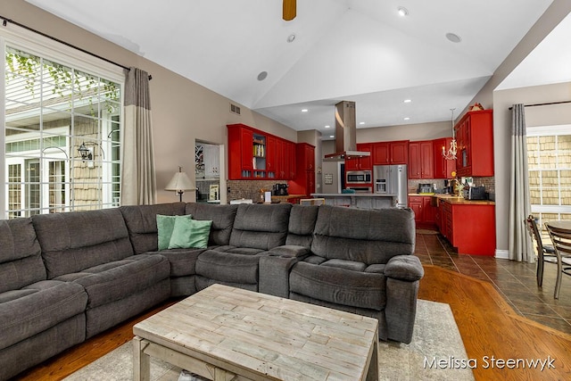 living room with ceiling fan, dark hardwood / wood-style flooring, and high vaulted ceiling