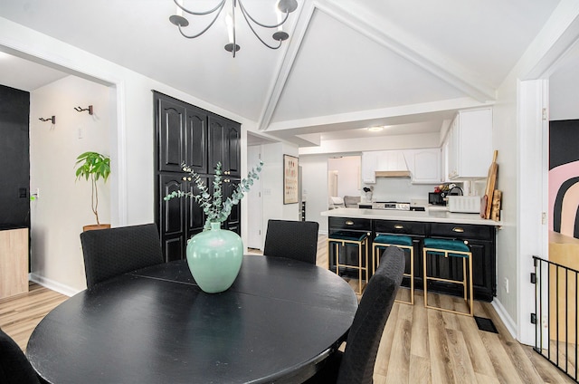 dining area featuring vaulted ceiling with beams, light hardwood / wood-style floors, and a notable chandelier