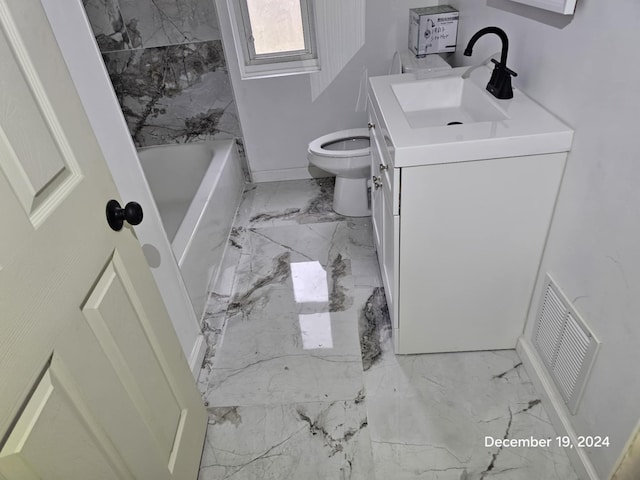 bathroom featuring a bathing tub, vanity, and toilet