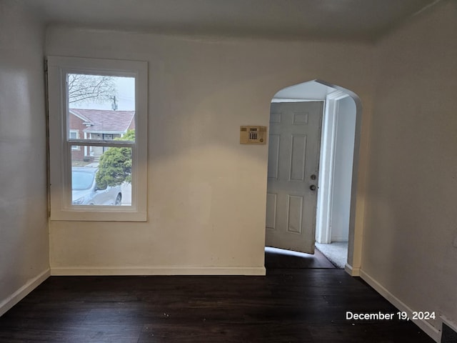 unfurnished room with dark hardwood / wood-style flooring