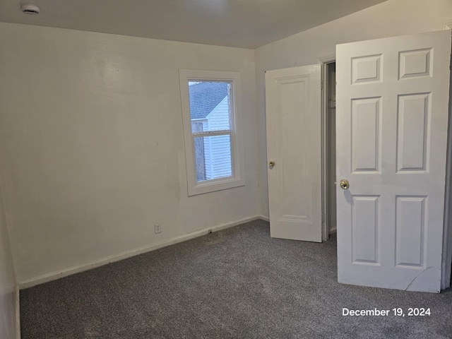 unfurnished bedroom featuring dark colored carpet