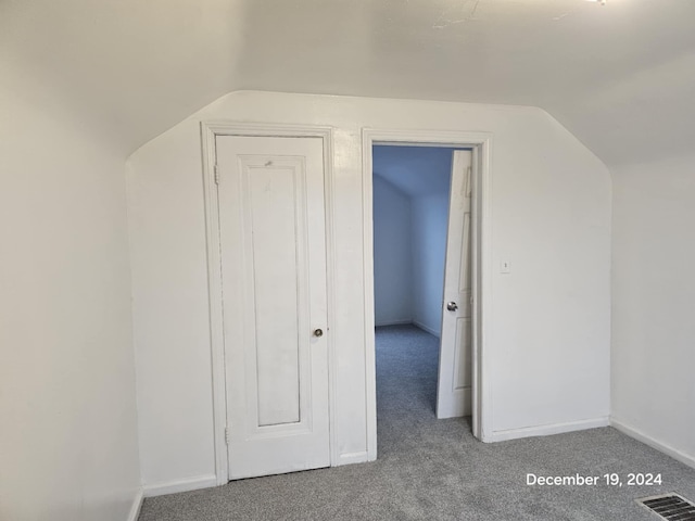 additional living space with carpet flooring and vaulted ceiling