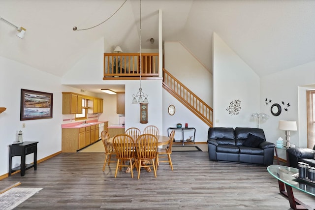 dining room with sink, high vaulted ceiling, and wood-type flooring