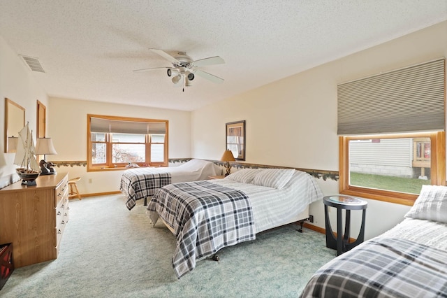 carpeted bedroom with a textured ceiling and ceiling fan