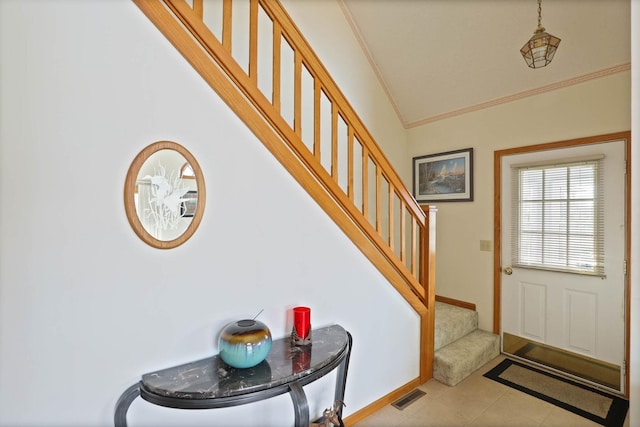 foyer featuring ornamental molding and light tile patterned floors