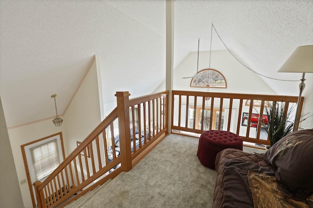 corridor featuring carpet, a textured ceiling, and lofted ceiling