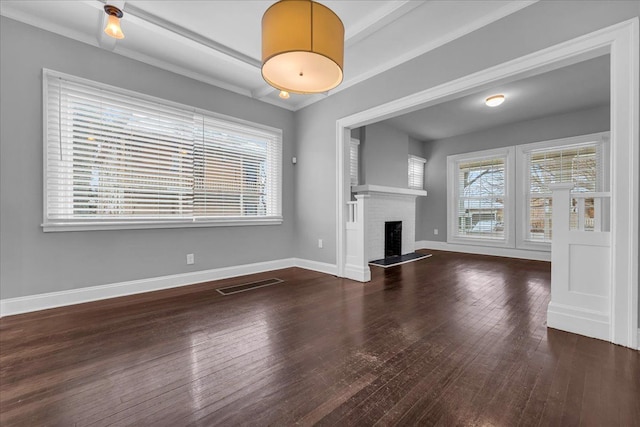 unfurnished living room with a healthy amount of sunlight, dark hardwood / wood-style flooring, and a fireplace