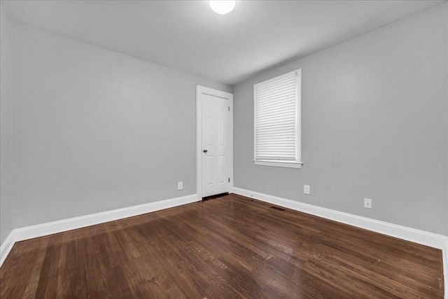 unfurnished room with dark hardwood / wood-style floors