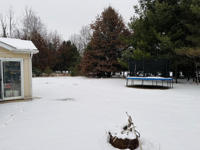 snowy yard featuring a trampoline