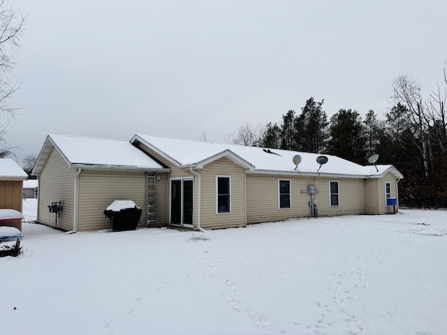 view of snow covered back of property