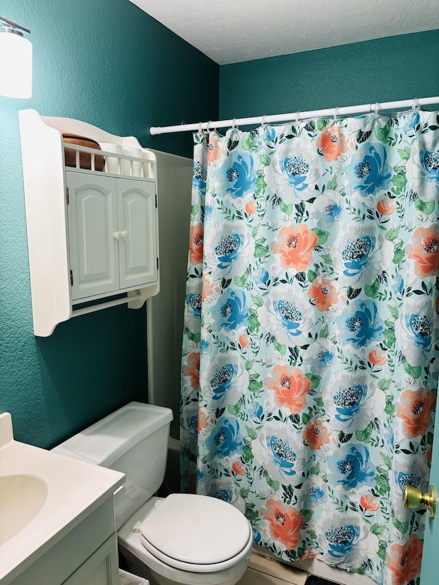 bathroom featuring vanity, a shower with shower curtain, a textured ceiling, and toilet