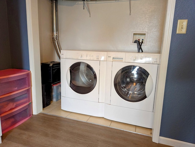 laundry room featuring washer and dryer and light tile patterned flooring