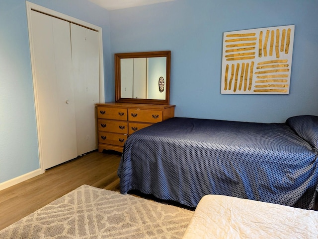 bedroom with a closet and light hardwood / wood-style flooring