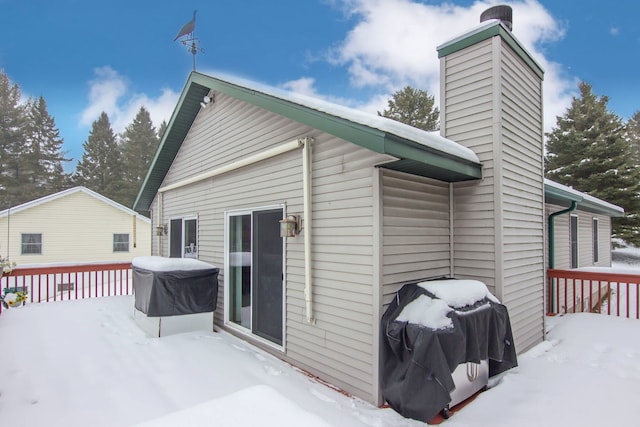 snow covered rear of property featuring a wooden deck