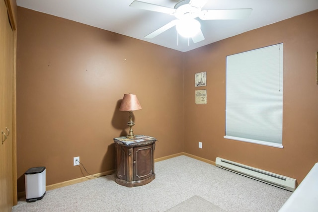 carpeted empty room featuring ceiling fan and a baseboard heating unit