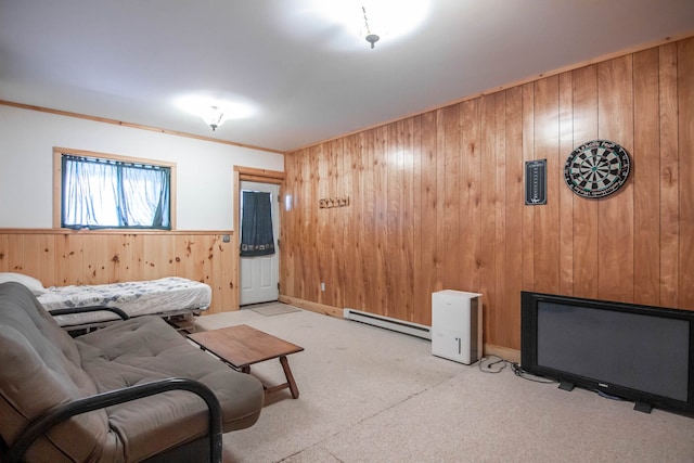 carpeted living room featuring baseboard heating, wood walls, and crown molding