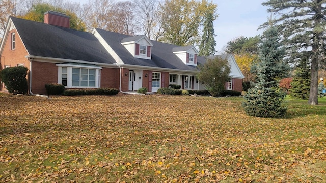 cape cod house featuring a front yard