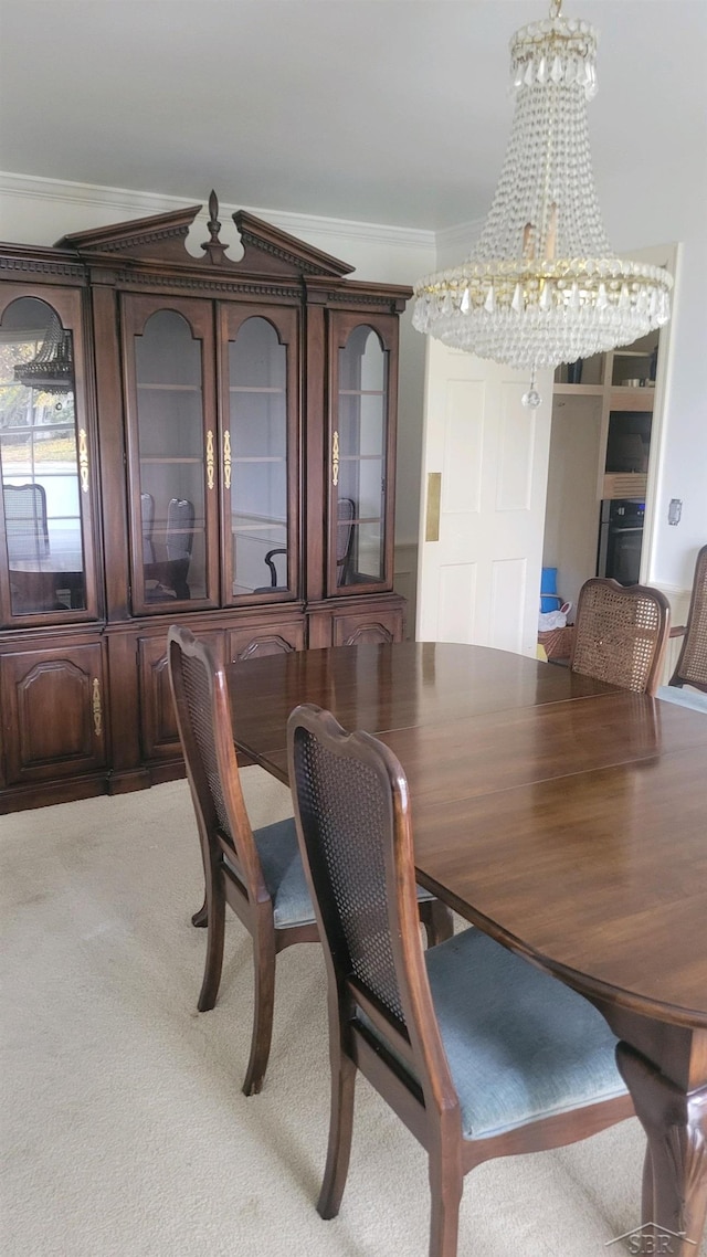 dining area featuring carpet, crown molding, and a notable chandelier