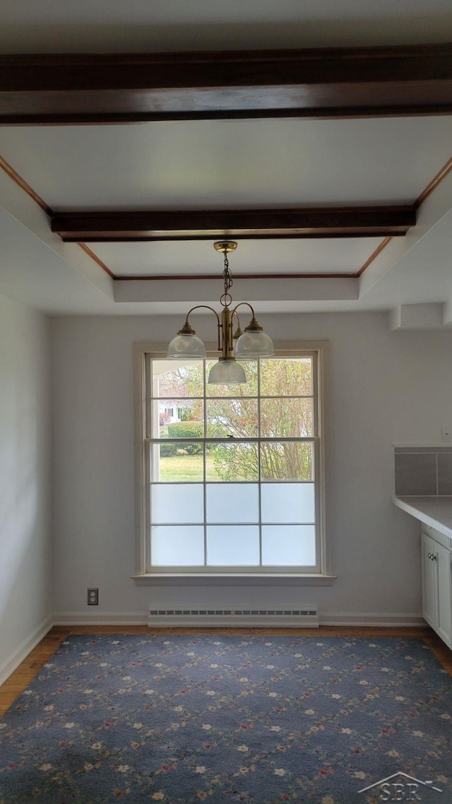 unfurnished dining area featuring a raised ceiling, an inviting chandelier, and a baseboard heating unit