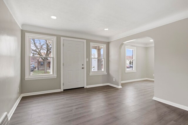 foyer entrance with crown molding and dark hardwood / wood-style flooring