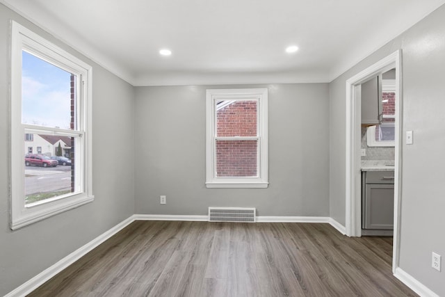 unfurnished room with light hardwood / wood-style flooring, plenty of natural light, and crown molding