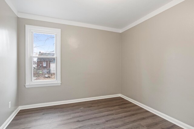 unfurnished room with ornamental molding and dark wood-type flooring