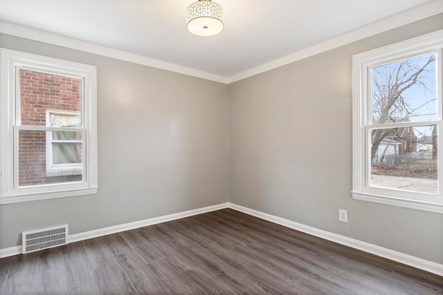 empty room featuring ornamental molding and dark hardwood / wood-style floors