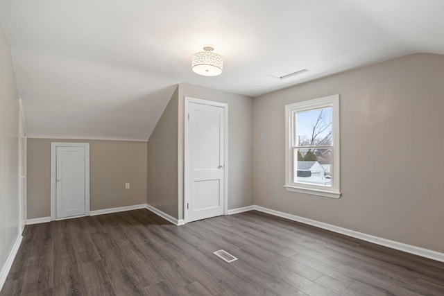 additional living space with dark hardwood / wood-style floors and lofted ceiling