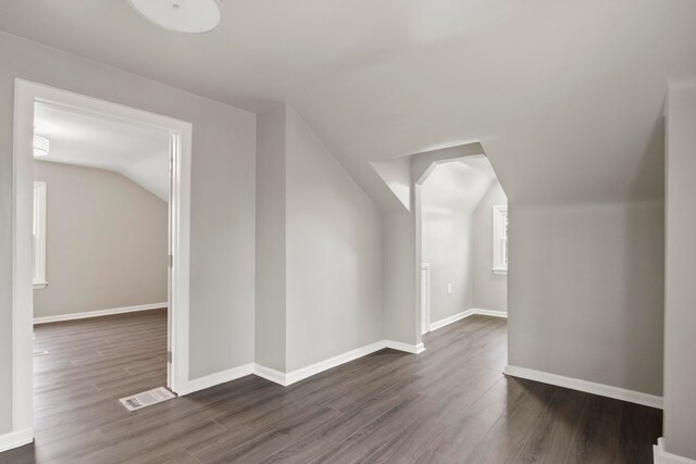 additional living space with dark hardwood / wood-style floors and lofted ceiling