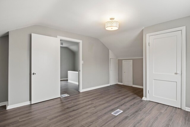 additional living space with lofted ceiling and dark hardwood / wood-style floors