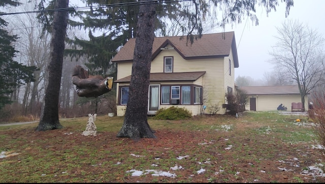 view of front of home with a garage and an outbuilding