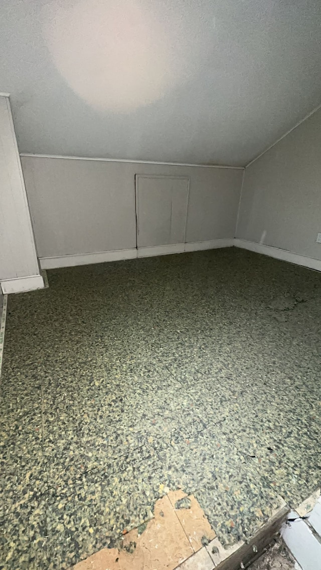 bonus room featuring lofted ceiling and a textured ceiling