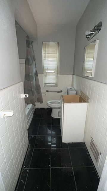 bathroom with shower / bathtub combination with curtain, tile walls, tile patterned floors, and toilet