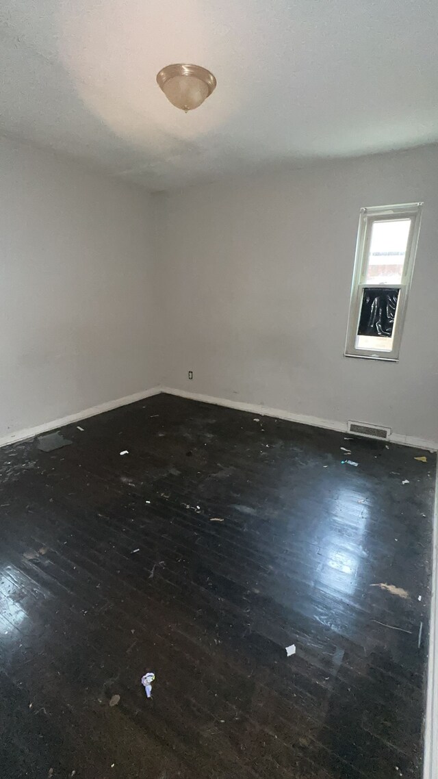 empty room with dark hardwood / wood-style flooring