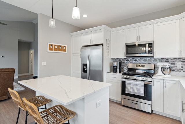 kitchen with white cabinetry, a center island, hanging light fixtures, tasteful backsplash, and appliances with stainless steel finishes