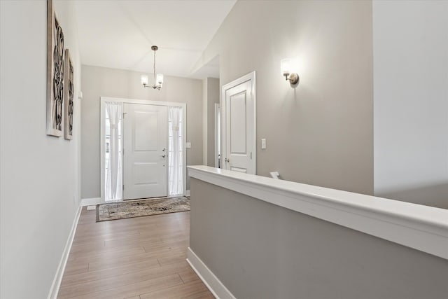 foyer featuring light hardwood / wood-style floors and a notable chandelier