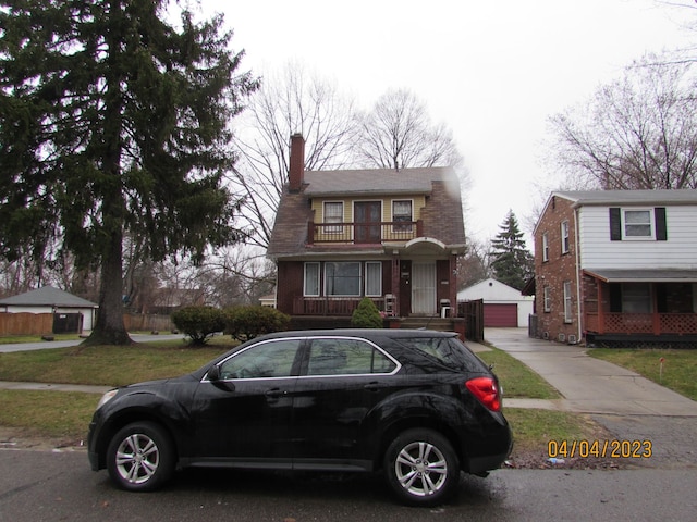 view of front facade featuring a balcony, a garage, and an outdoor structure