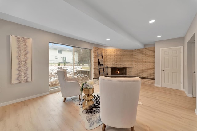 interior space featuring light wood-type flooring and a brick fireplace